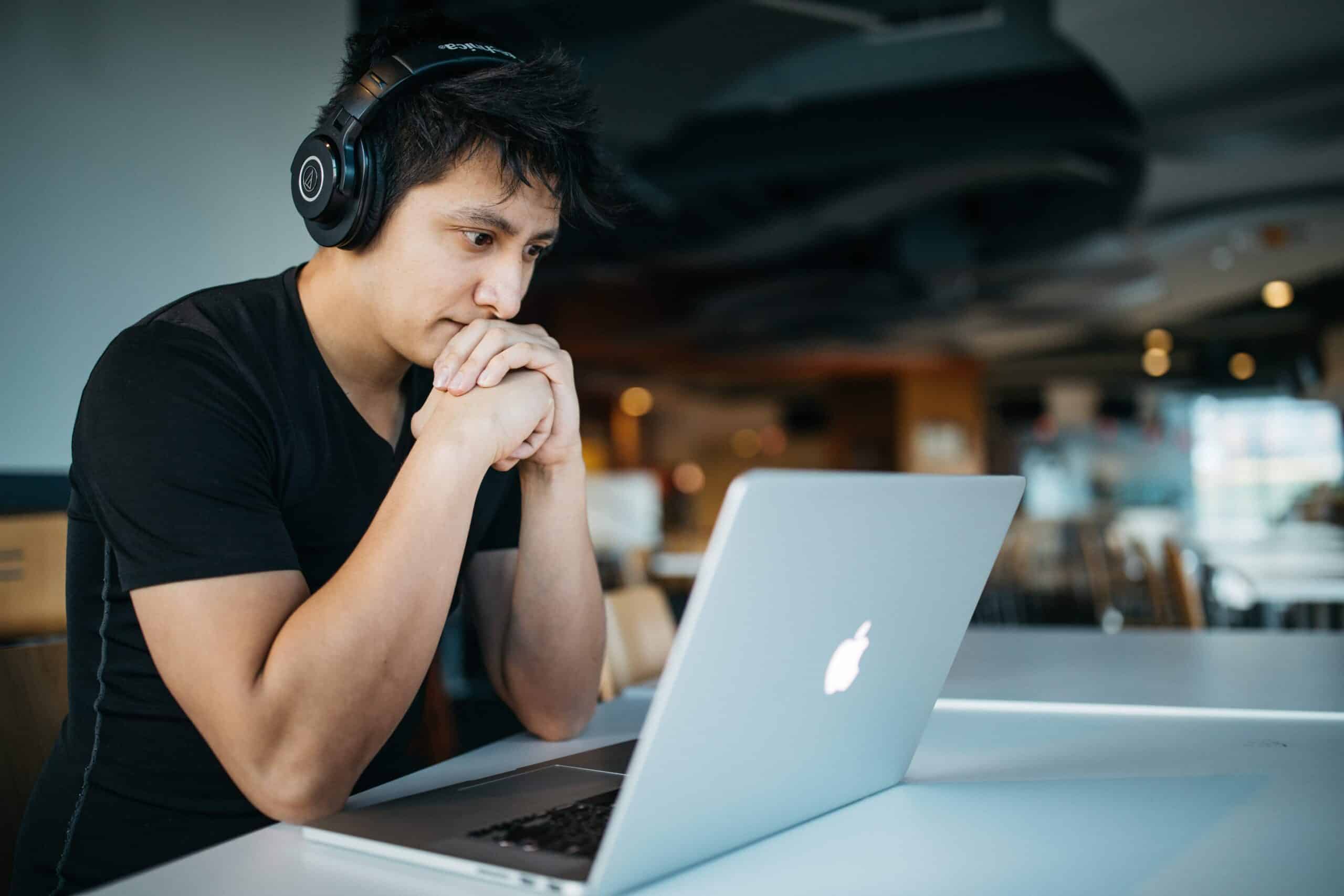 Student working at laptop with headphones